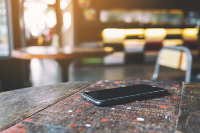 Close-up of smart phone on table at restaurant