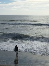 Rear view of silhouette man standing at beach
