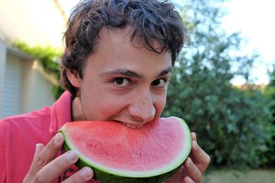 Close-up of young man eating watermelon