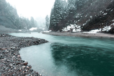 Scenic view of river flowing during winter