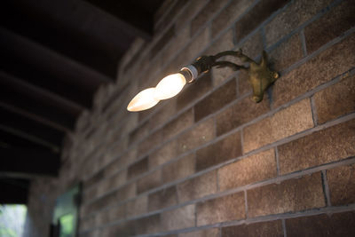 Low angle view of illuminated light bulbs hanging from ceiling