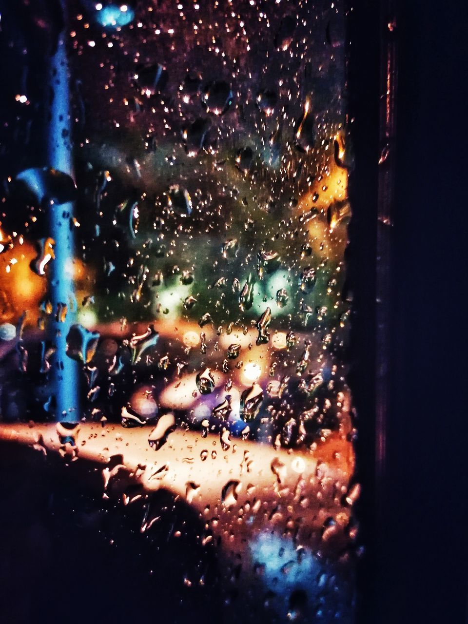 RAINDROPS ON GLASS WINDOW AT NIGHT