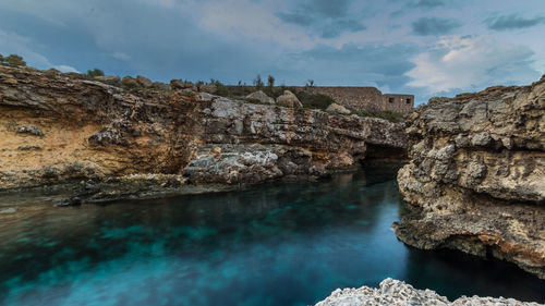 Rock formations by sea against sky