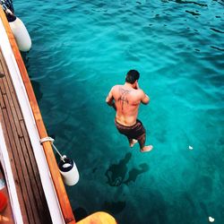 High angle view of shirtless man in sea