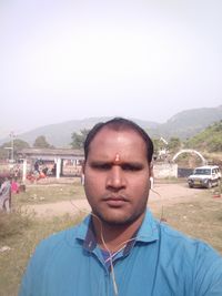 Portrait of young man standing against clear sky