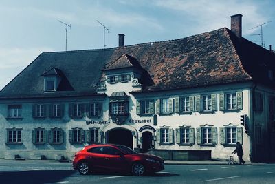 Cars on house against sky in city