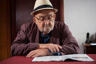 View of senior man reading at table