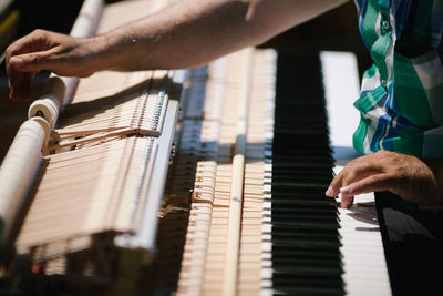 Midsection of pianist playing piano