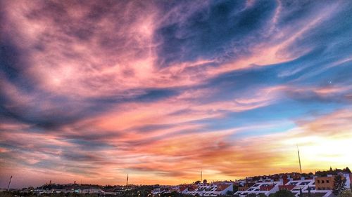 View of buildings against cloudy sky during sunset