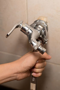 Close-up of hand holding faucet