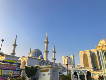 Buildings in city against clear blue sky