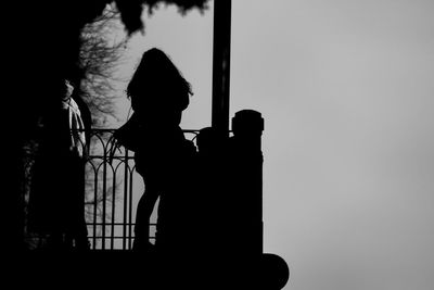 Silhouette boy standing against clear sky