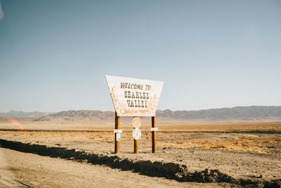 Venice beach, usa - december 6, 2017: empty dry road in desert and signpost welcome to searles valley on bright day