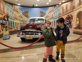 Full length of boys standing by car