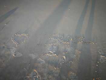 High angle view of text on sand