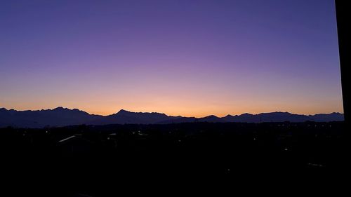 Silhouette mountains against clear sky at sunset