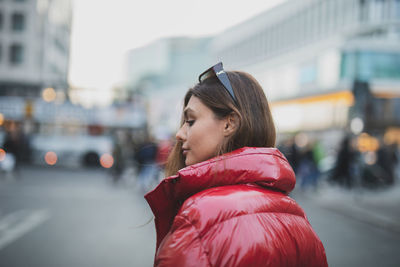 Side view of woman wearing jacket in city