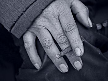 Cropped image of hand holding cigarette