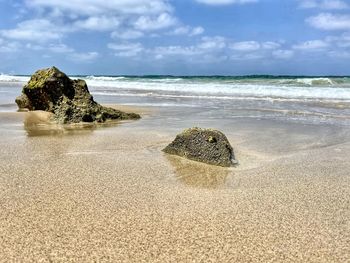 Rocks on beach against sky