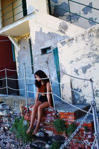 Portrait of woman sitting on abandoned building