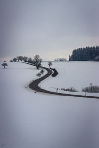 Scenic view of snow covered land against sky