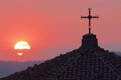 Cross on beach against sky during sunset