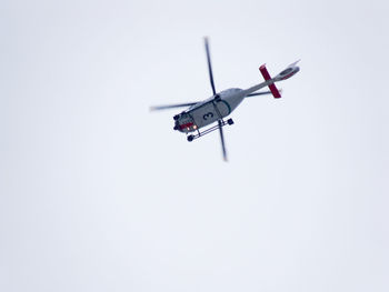 Low angle view of helicopter flying against clear sky