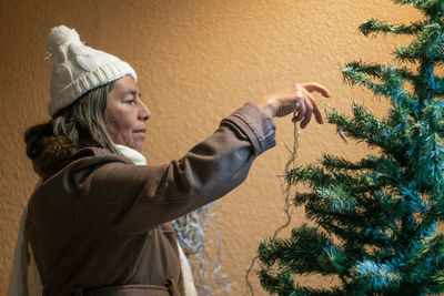 Side view of woman with christmas tree