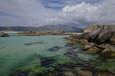 Scenic view of sea and mountains against sky