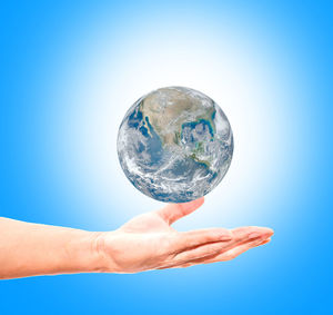 Midsection of person holding umbrella against blue background