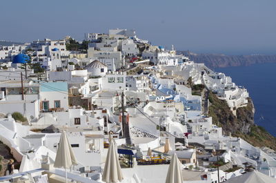 High angle view of town by sea against clear sky