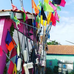 Low angle view of flags hanging on roof against sky