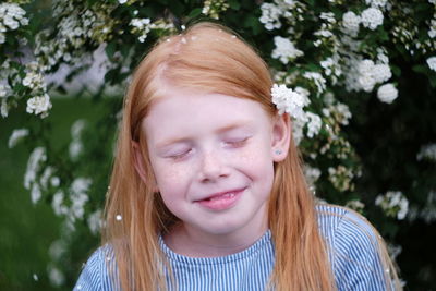 Close-up of cute girl with eyes closed against tree