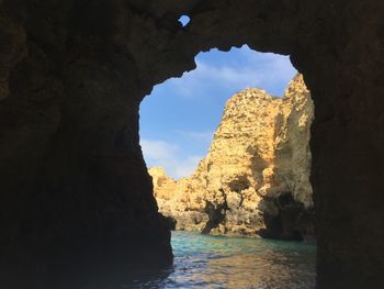 Rock formation in sea against sky