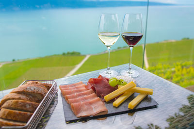 Close-up of food and drink on table against sea