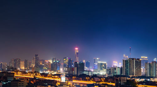 Illuminated buildings in city against sky at night