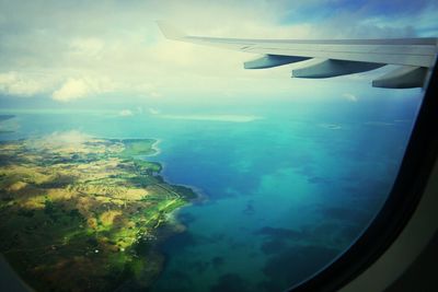 Cropped image of airplane wing over landscape