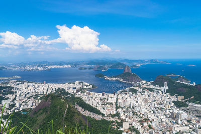 High angle view of city by sea against sky