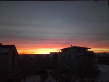 Silhouette buildings against sky at sunset