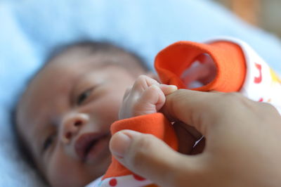Close-up of baby girl holding mothers hand