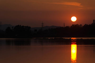 Scenic view of lake against orange sky during sunset