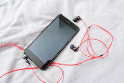High angle view of mobile phone on bed