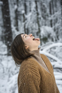 Side view of young woman looking away on snow