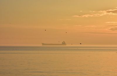 Scenic view of sea against orange sky