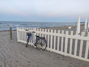 Bicycle on beach against sky