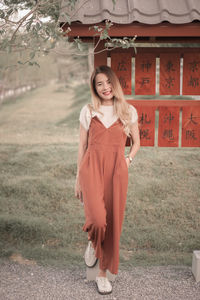 Portrait of young woman standing on field