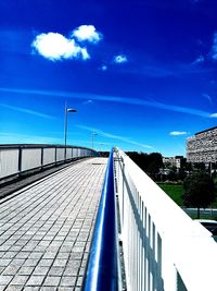 View of bridge in city against blue sky
