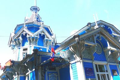 Low angle view of ferris wheel against blue sky