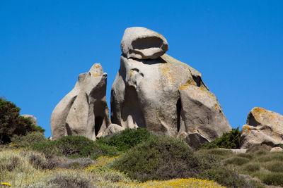 Low angle view of rock formation against clear blue sky