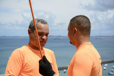 Man with helmet, glove and equipment practicing rappel on elevador lacerda